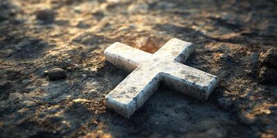 Weathered stone cross resting on cracked earth illuminated by soft light during twilight hours photo