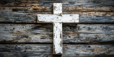 Weathered white wooden cross mounted on distressed wooden wall demonstrating rustic decor photo