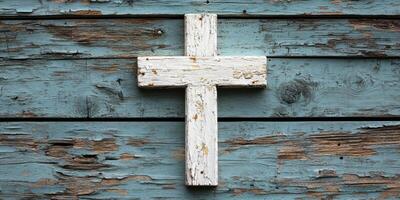 White wooden cross on weathered blue rustic wooden background in a quiet setting suggesting peace and reflection photo