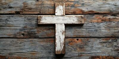 Weathered wooden cross resting on a rustic wooden surface, symbolizing faith and spirituality photo