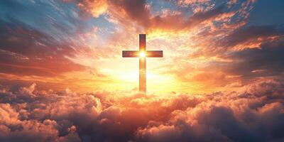 Beautiful sunset with a cross silhouette above clouds illuminating the sky in warm colors photo