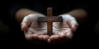 Hands holding a wooden cross symbolizing faith and spirituality in a serene indoor setting photo