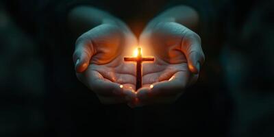 Hands holding a glowing cross in a dark setting during a moment of reflection photo