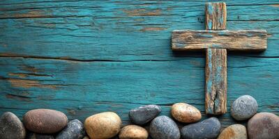 Wooden cross on weathered blue wood surface adorned with smooth stones creating a serene and peaceful atmosphere photo