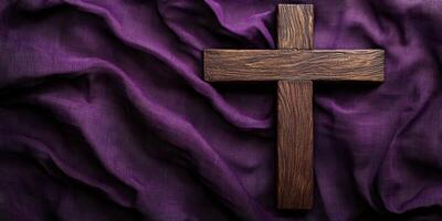 Wooden cross placed on textured purple fabric, symbolizing faith and spirituality during a solemn occasion photo