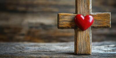 Wooden cross with red heart placed on rustic wooden surface in a serene and meaningful display of faith and love photo