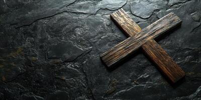 Rustic wooden cross placed on a textured dark stone surface creating a solemn atmosphere for reflection and spirituality photo