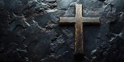 Wooden cross resting on textured dark stone surface in a solemn and reflective setting photo