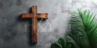 Wooden cross mounted on textured wall with green foliage accents in modern decor setting photo