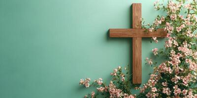 Wooden cross adorned with delicate flowers against a teal wall, showcasing a serene and contemplative atmosphere photo