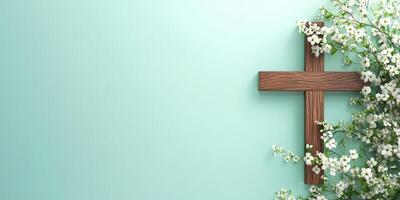 Wooden cross adorned with delicate white flowers against a soft turquoise background in a serene setting photo