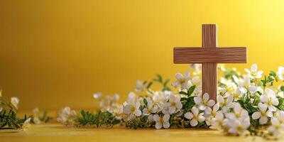 Wooden cross surrounded by white flowers on a vibrant yellow background during springtime photo