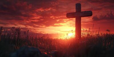 Sunset over a wooden cross in a field, illuminating the sky with vibrant colors and casting long shadows on the ground photo