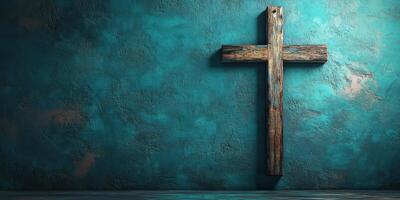 Weathered wooden cross mounted on textured turquoise wall in a serene setting photo
