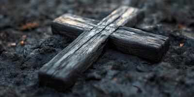 Wooden cross resting on dark ashes in a solemn landscape during twilight photo
