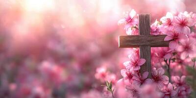 Beautiful wooden cross surrounded by blooming pink flowers in a serene setting at sunset photo