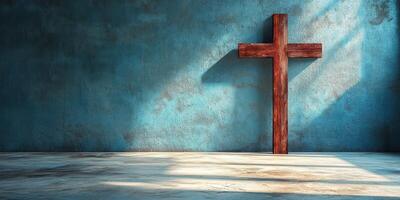 Rustic wooden cross stands against a textured blue wall casting dramatic shadows in a serene setting photo