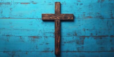 Wooden cross on a blue wooden background symbolizes faith and spirituality in a serene setting photo
