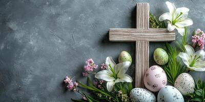 Decorative Easter arrangement with colored eggs, flowers, and a wooden cross on a textured background photo