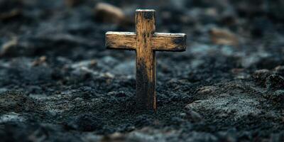 Wooden cross standing in dark soil at sunset, symbolizing loss and remembrance in a tranquil setting photo
