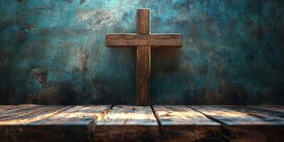 Wooden cross stands against a blue textured wall in soft natural light photo