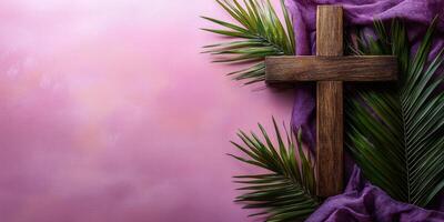 Wooden cross adorned with palm leaves and purple fabric on a softly lit background in preparation for Easter celebration photo
