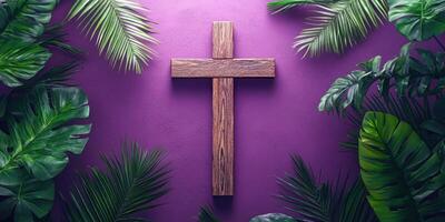 Wooden cross surrounded by lush green leaves against vibrant purple backdrop in a tranquil setting photo