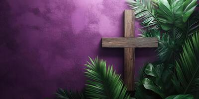 Wooden cross adorned by vibrant green leaves against a purple wall in a tranquil setting photo