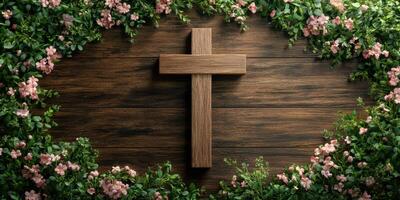 Wooden cross surrounded by flowers and greenery on a rustic wooden background photo