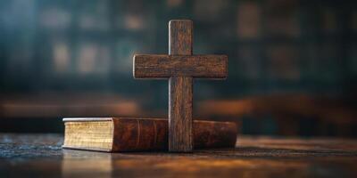 Wooden cross placed on a table next to an old book in a serene, dimly lit environment photo