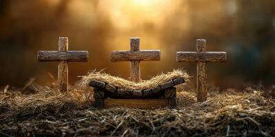 Rustic nativity scene featuring wooden crosses and a bed of straw at sunset photo