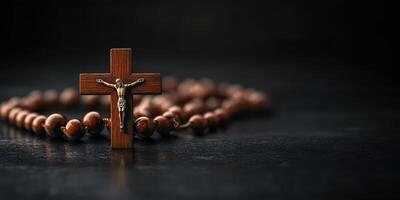 Wooden crucifix and rosary beads placed on a dark stone surface highlighting spiritual connection and faith photo