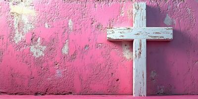 Rustic white cross against vibrant pink wall creates a striking contrast in an artistic setting photo