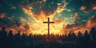 Sunset gathering at a large cross with silhouettes of worshippers raising hands to the sky photo
