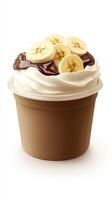 Delicious frozen dessert topped with fresh banana slices and chocolate sauce in a cup photo