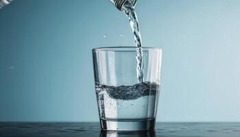 Refreshing Clear Water Flowing Into a Glass Against a Soft Blue Background photo