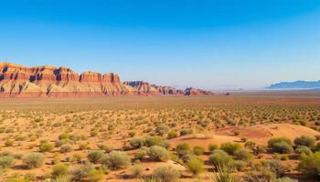 Expansive Desert Landscape with Red Rock Formations Under a Clear Blue Sky photo