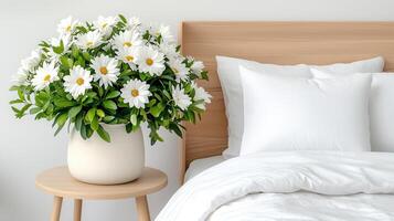 White Daisies in Vase on Wooden Side Table Near White Bed and Pillows photo
