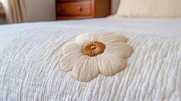 Embroidered Flower Detail on Textured Cream Bedspread Close Up photo