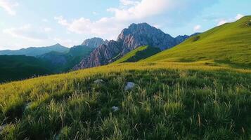 Serene Mountain Meadow Landscape Rolling Hills Lush Grass Majestic Peaks at Sunset photo