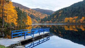 Serene Autumn Lake with Blue Wooden Dock and Colorful Foliage Reflection photo