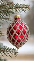 Close-up of a decorative red christmas ornament hanging from pine tree branches photo