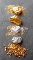 Glittering gold and silver rocks with shiny mineral deposits on a gray surface photo
