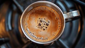 Top view of freshly brewed espresso coffee with rich crema in a stainless steel cup photo