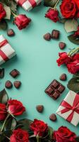 Red roses and chocolates with gift boxes on a teal background for valentine's day photo