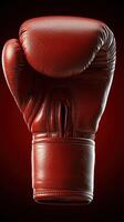 Red boxing glove isolated on dark background for sports and fitness promotion photo