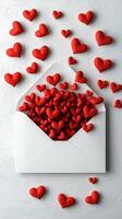 Envelope filled with red hearts on a textured white background for valentine's day photo