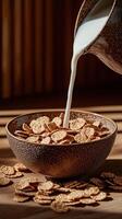 Pouring milk into bowl of crisp cereal on wooden table with sunlight photo