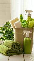 Collection of green cleaning supplies and towels in a bucket on a white wooden surface photo