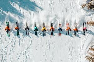 Aerial view of group of skiers in colorful ski gear on snowy mountain photo